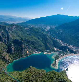 Luftaufnahme von einer von Pinien geprägten Berglandschaft am Ufer des türkischen Mittelmeers.
