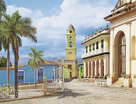 Kolonialbauten neben Palmen auf Kuba