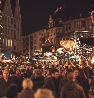 Eine Menschenmasse bewegt sich im dunkel über den beleuchteten Frankfurter Weihnachtsmarkt