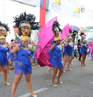 Traditionell verkleidete Damen, in blauem Fransenkleid und Kopfschmuck sind in einer Formation aufgestellt und warten bis ihre Choreographie beginnt.