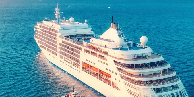 Ein großes, weißes Kreuzfahrtschiff gleitet auf dem blauen Meer