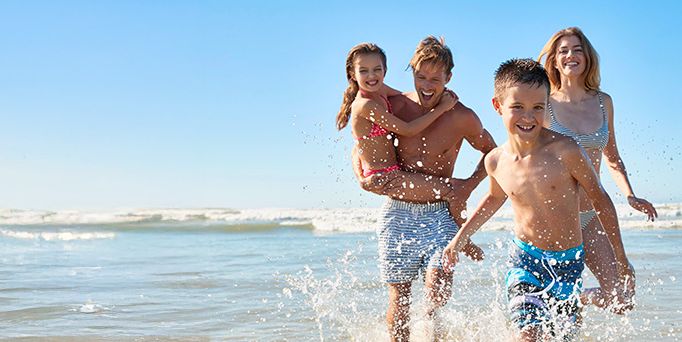 Familie mit zwei Kindern am Strand