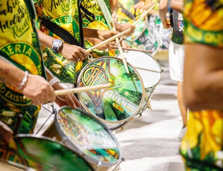 Nahaufnahme von brasilianischen Trommlern, welche in grün, gelb gekleidet sind.