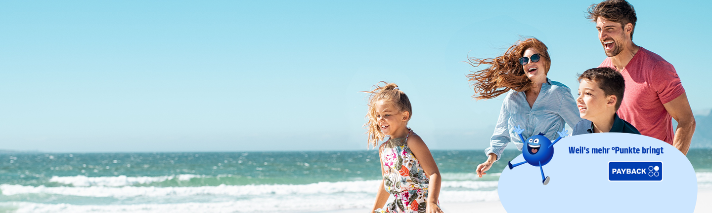 Familie mit zwei Kindern läuft am Strand am Meer entlang.