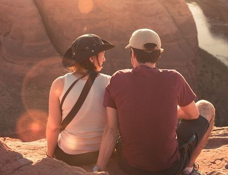 Reiseziele weltweit: Eine Frau und ein Mann sitzen in Outdoor Kleidung am Rand eines Canyons