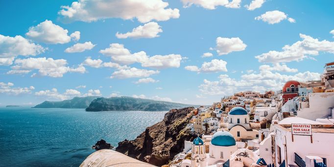 Reisetrends 2026: Ein mediterranes Dorf direkt am Meer mit weiß-blauen Häusern.