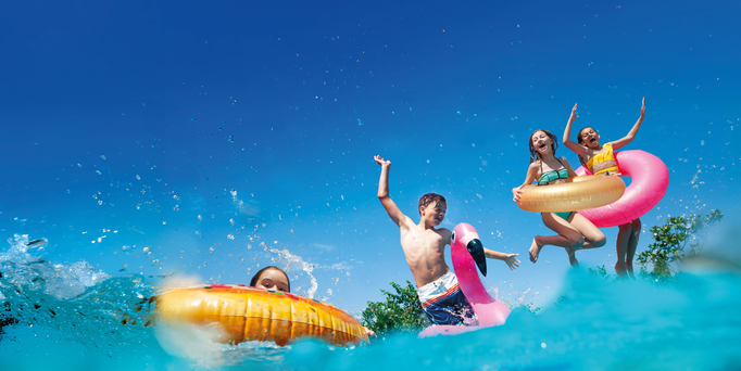 Großes Kreuzfahrtschiff auf ruhigem Meer vor einer Küstenstadt mit Hügeln im Hintergrund