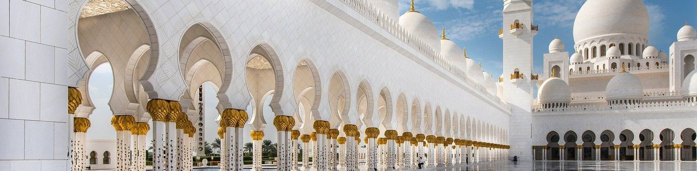 Reiseziele weltweit: Eine weiße, prächtige Moschee unter blauem Himmel