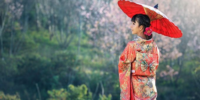 Reisetrends 2026: Eine japanische Frau in traditioneller Kleidung mit Sonnenschirm