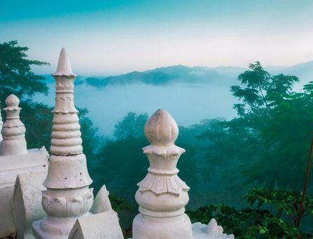 Ein mystische Berglandschaft in Nebel getaucht mit weißem Tempel.