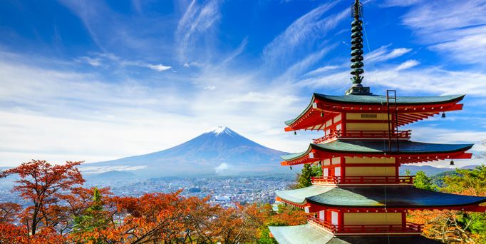 Ein japanischer Tempel vor einer Stadt, die an einen Berg grenzt.