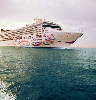 Ein weißes Kreuzfahrtschiff mit spitzem Bug und bunter, floraler Bemalung.