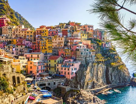 Eine steile Kippe mit bunten, mediterranen Häusern liegt direkt am Meer.