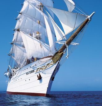 Alle Reiseziele: Ein riesiges, weißes Segelschiff auf dem tiefblauen Meer
