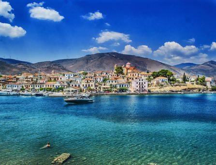 Ein lachendes Paar geht mit Gepäck auf das Kreuzfahrtschiff "Mein Schiff" zu.