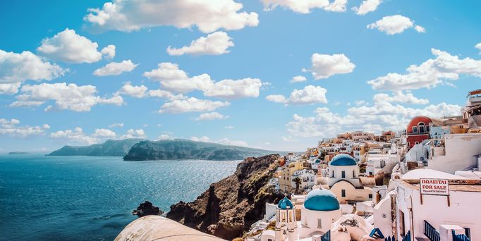 Reisetrends 2026: Ein mediterranes Dorf direkt am Meer mit weiß-blauen Häusern.