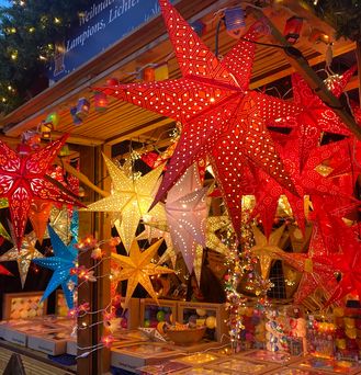 Ein Stand auf dem Aachen Weihnachtsmarkt bietet beleuchtete Weihnachtssterne an