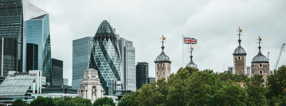 Die Skyline von London mit modernen sowie historischen Gebäuden erstreckt sich unter grauem Himmel.