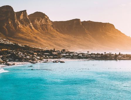 Reiseziele weltweit: Das blaue Meer grenzt an eine steile Berglandschaft