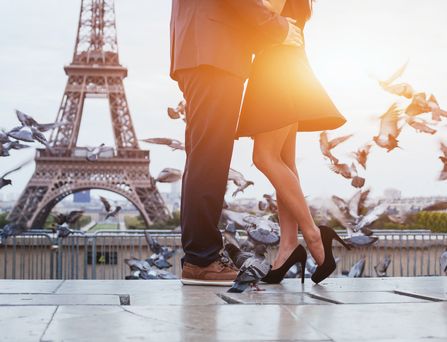 Kurzurlaub Valentinstag: Vor dem Eifelturm in Paris steht ein Paar und umarmt sich.
