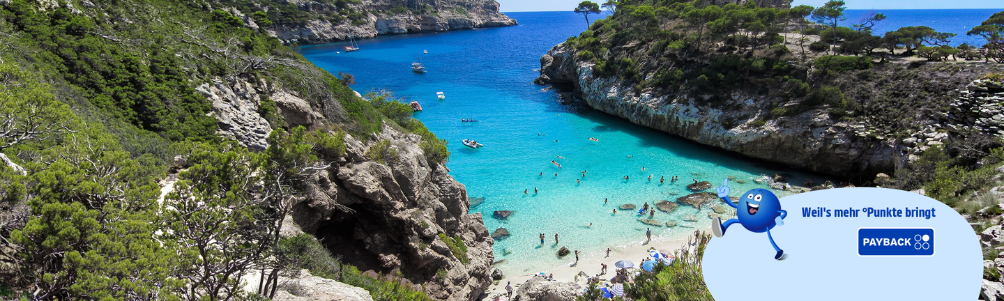Eine Bucht mit türkisem Wasser und weißem Sandstrand..