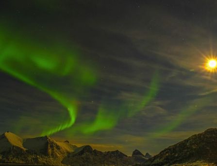 Reisetrends 2026: Der Nachthimmel über verschneiten Bergen mit Polarlichtern