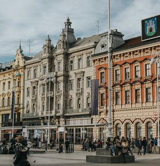 Eine schöne Altbauhäuserfassade mit einer digitalen Uhr, auf der Zagreb steht