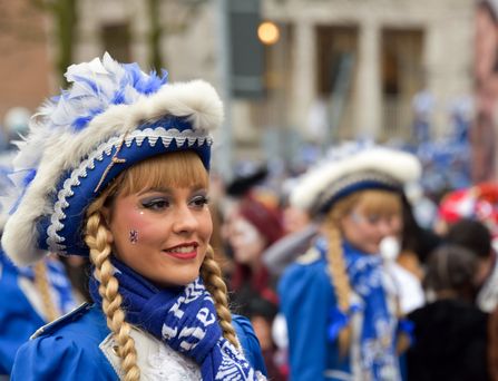 Ein "Funkemariechen" mit blau-weißer, traditioneller Verkleidung, Perücke und Hut.