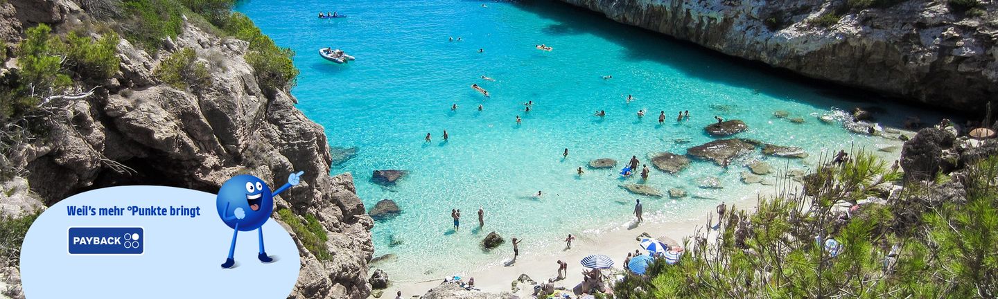 Eine Bucht mit türkisem Wasser und weißem Sandstrand..