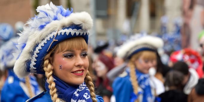 Ein "Funkemariechen" mit blau-weißer, traditioneller Verkleidung, Perücke und Hut.