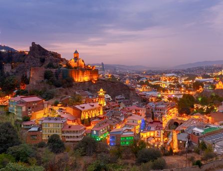 Eine Kirche ragt in den blauen Himmel daneben eine Palme