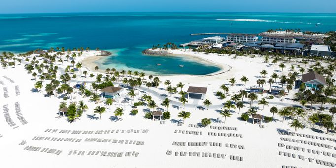 Ein weißer Sandstrand mit einer weitläufigen Hotelanlage und Palmen direkt am Strand.