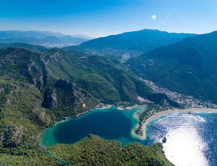 Luftaufnahme von einer von Pinien geprägten Berglandschaft am Ufer des türkischen Mittelmeers.