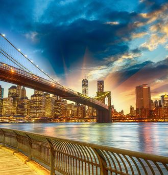 Die Skyline von New York unter dem dämmernden, orangenen Himmel.