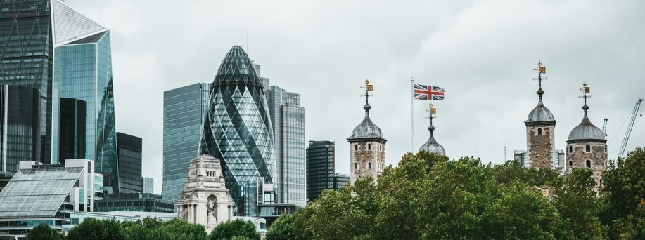 Die Skyline von London mit modernen sowie historischen Gebäuden erstreckt sich unter grauem Himmel.