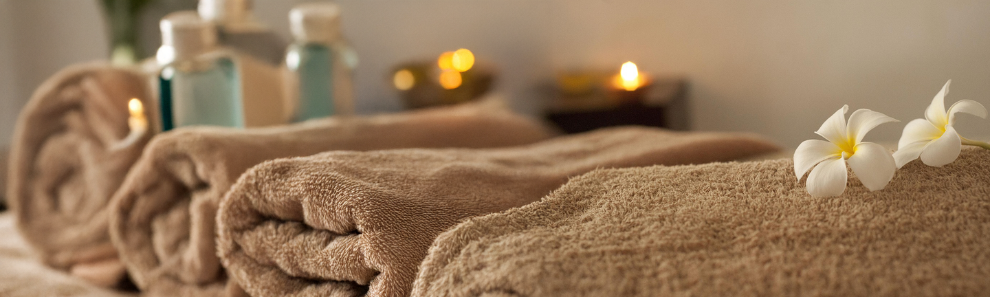 Wellnessraum mit Handtüchern, Kerzen und Blüten