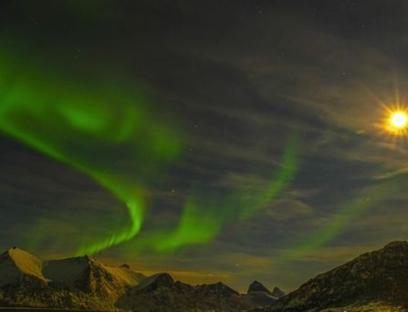 Reisetrends 2026: Der Nachthimmel über verschneiten Bergen mit Polarlichtern
