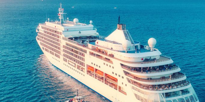 Ein großes, weißes Kreuzfahrtschiff gleitet auf dem blauen Meer