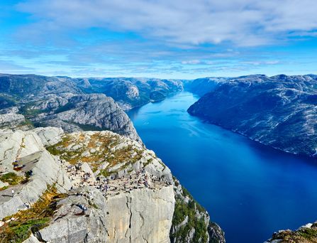 Ein tiefblauer Fjord zwischen steinigen, rauen Felsen.