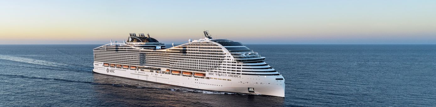 Ein weißer, karibischer Strand mit Palmen am türkis-blauen Meer