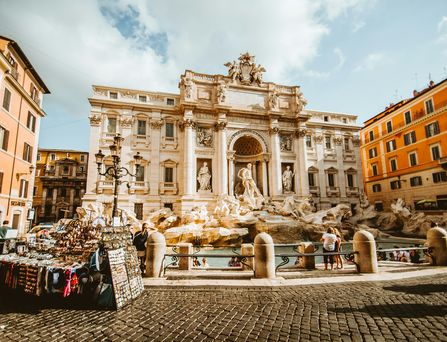 Der Trevibrunnen in Rom, davor steht ein mobiler Souvenirstand.