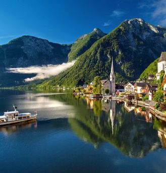 Ein kleines, hübsches Dorf mit Kirche befindet sich an einem Bergsee.
