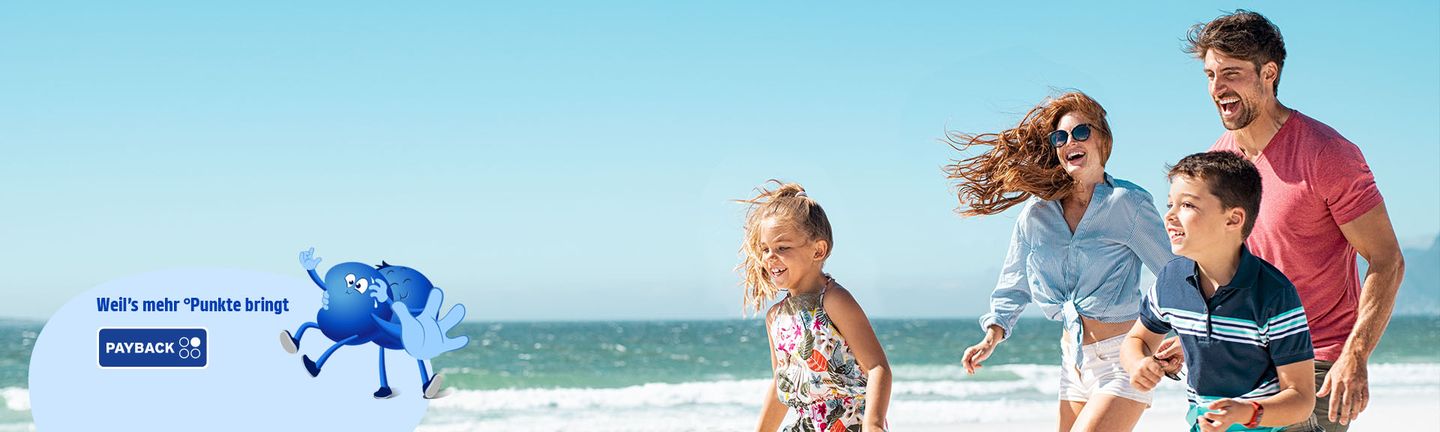 Eine glückliche Familie läuft lachend am Strand entlang